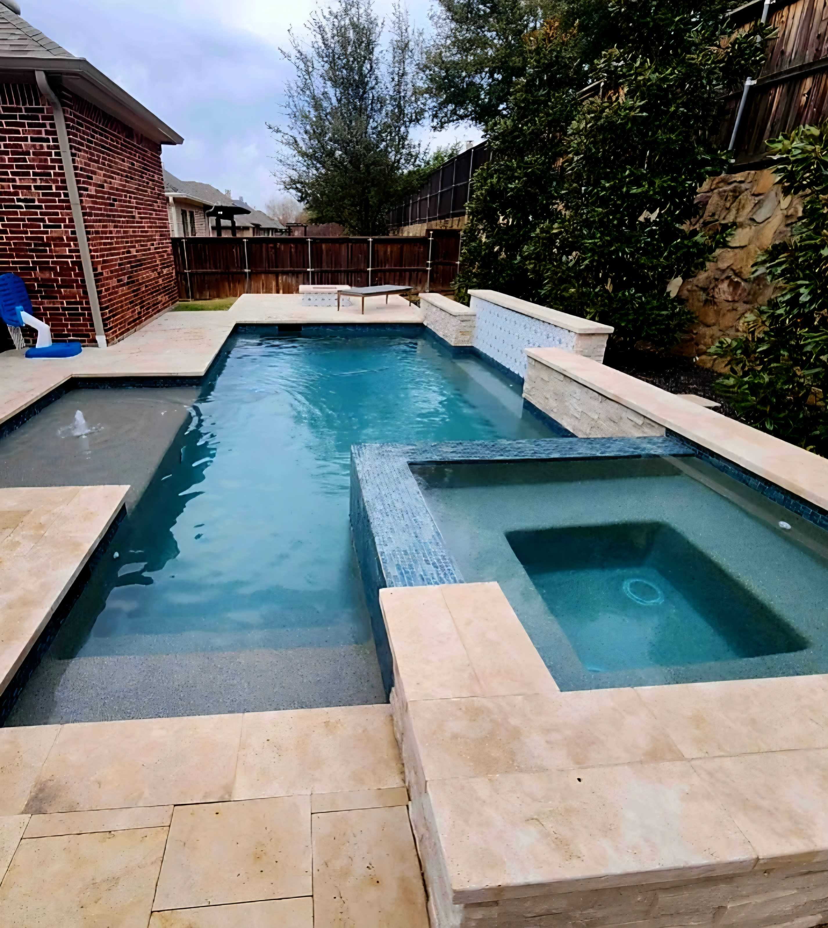 Modern pool remodel featuring spa spillover, new tile, and ambient lighting in Denton, TX