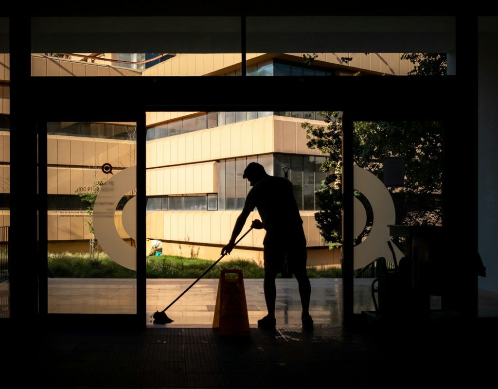 silhouette of man standing near glass window during daytime