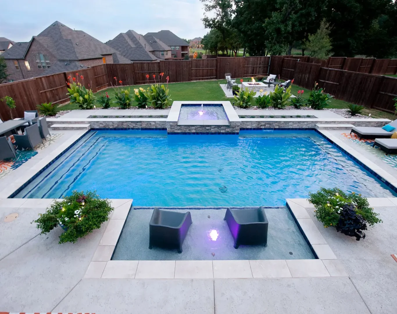 Modern pool remodel featuring spa spillover, new tile, and ambient lighting in Denton, TX