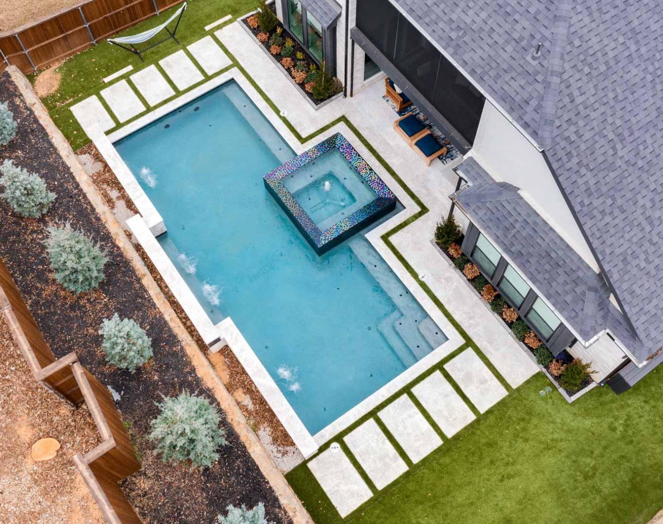 Modern pool remodel featuring spa spillover, new tile, and ambient lighting in Denton, TX